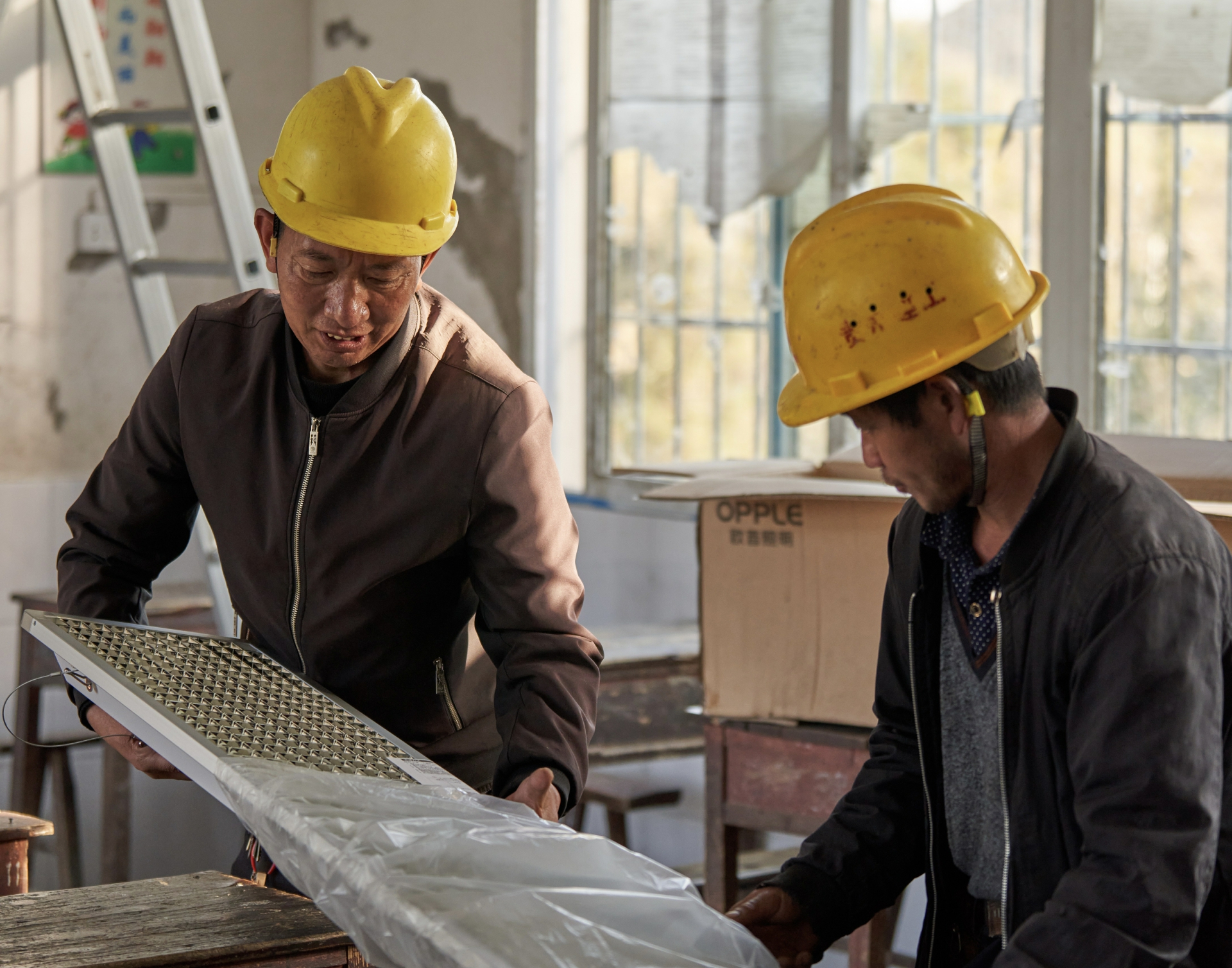 安装工人为教室安装符合国标的教室用灯